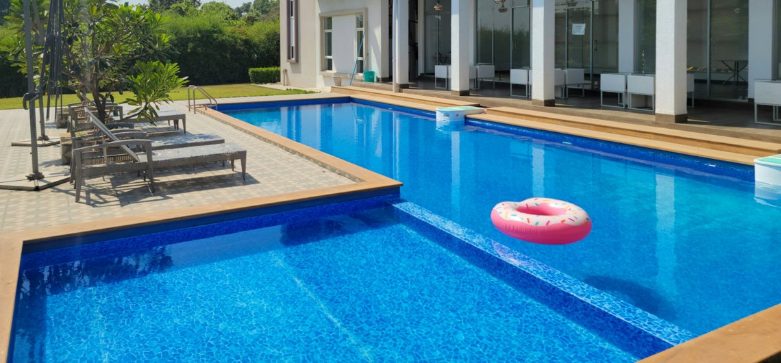 a large swimming pool with a lounge chair next to it
